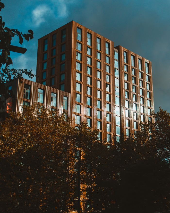 Crafting Captivating Headlines: Your awesome post title goes here Modern high-rise building in Leeds, UK, captured with a dynamic low-angle view, framed by trees.