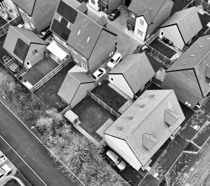 Black and white aerial photograph of suburban homes in Central Bedfordshire, showcasing rooftops and streets.