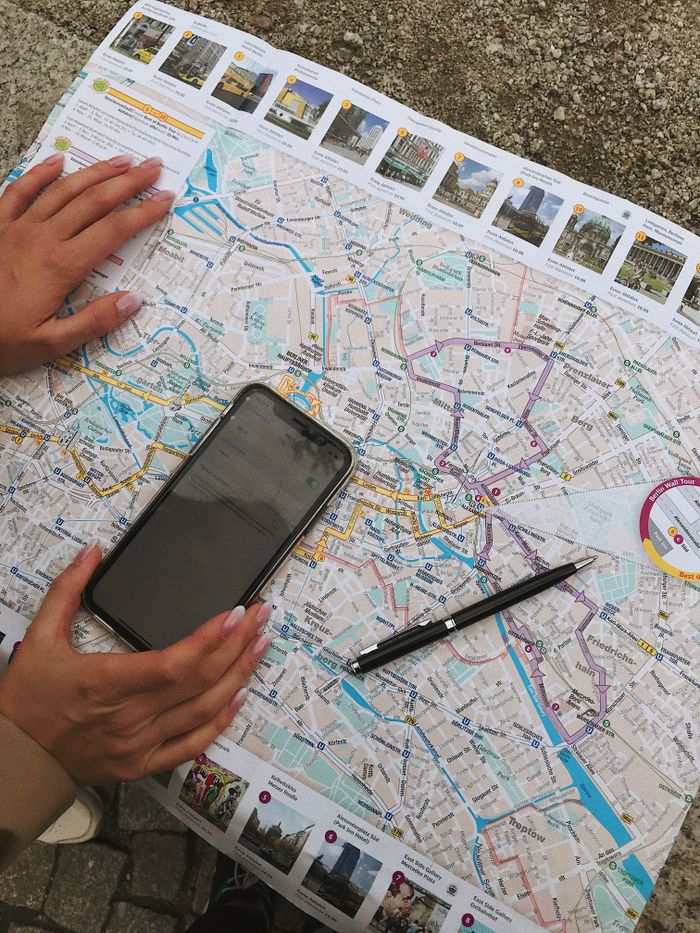 Services Hands interact with a Berlin map and smartphone, highlighting travel planning.